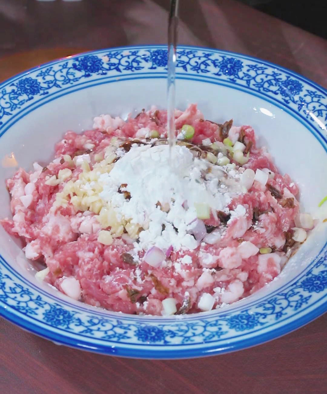 combine the minced pork and preserved vegetables with light soy sauce, oyster sauce, peanut oil, and cornstarch