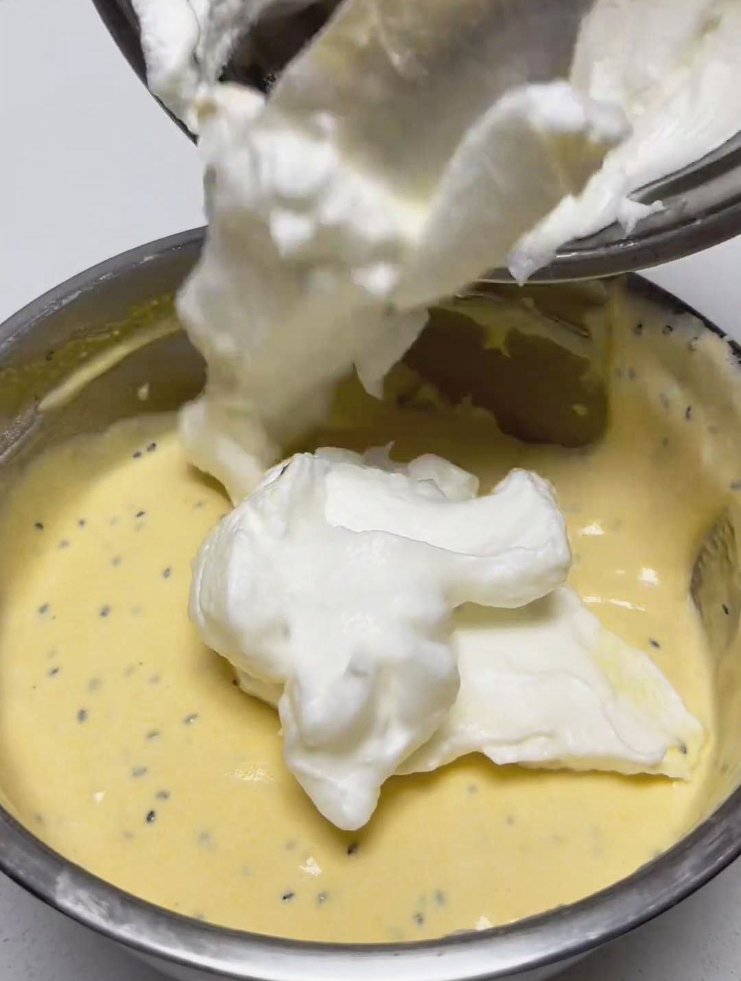 Gently fold one-third of the whipped egg whites into the egg yolk mixture