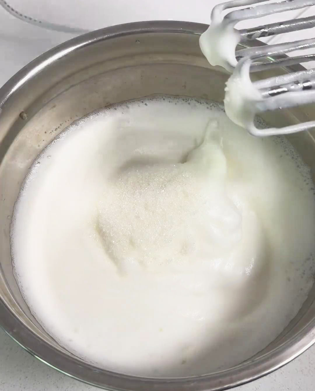 Gradually add the sugar in two to three stages while continuing to whip until you achieve stiff peaks