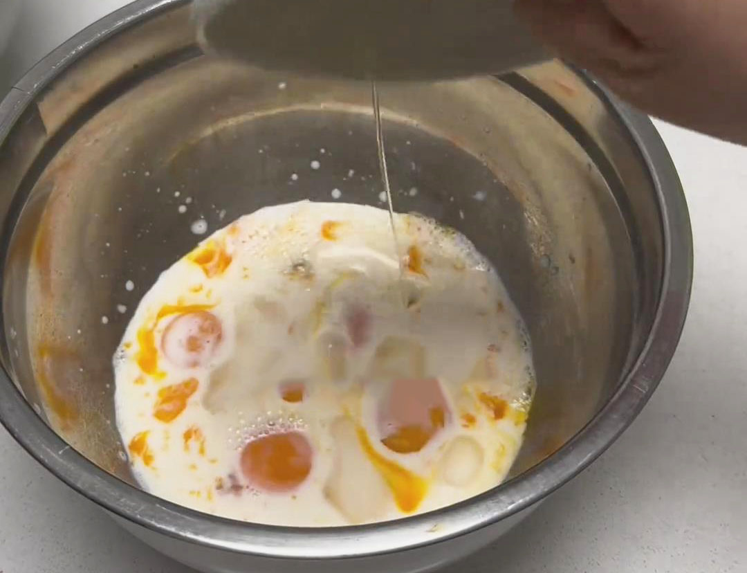 In the bowl with the egg yolks, add the milk and corn oil, mixing until well combined
