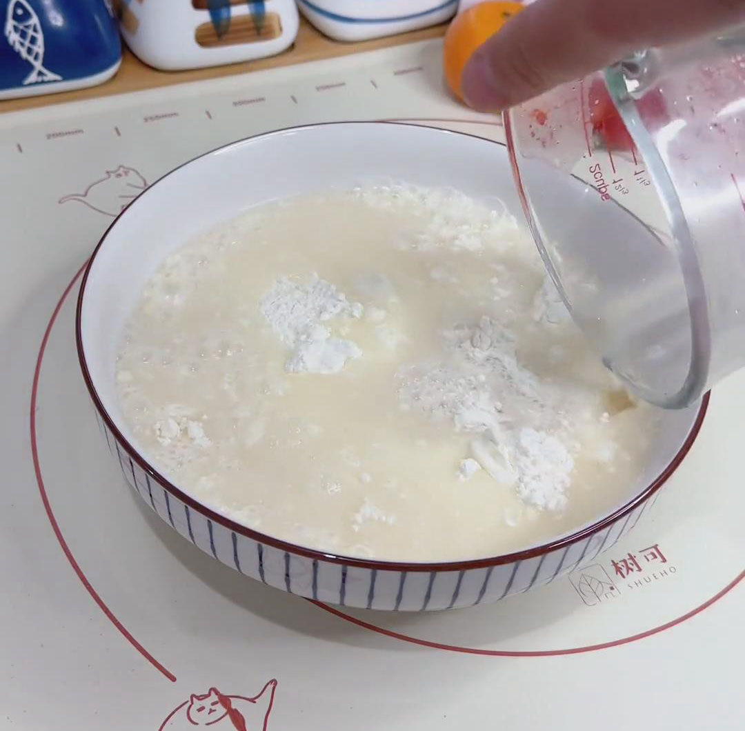 Gradually pour the yeast mixture into 300g of flour