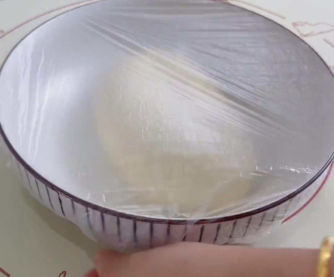 Place the dough in a container, cover with plastic wrap