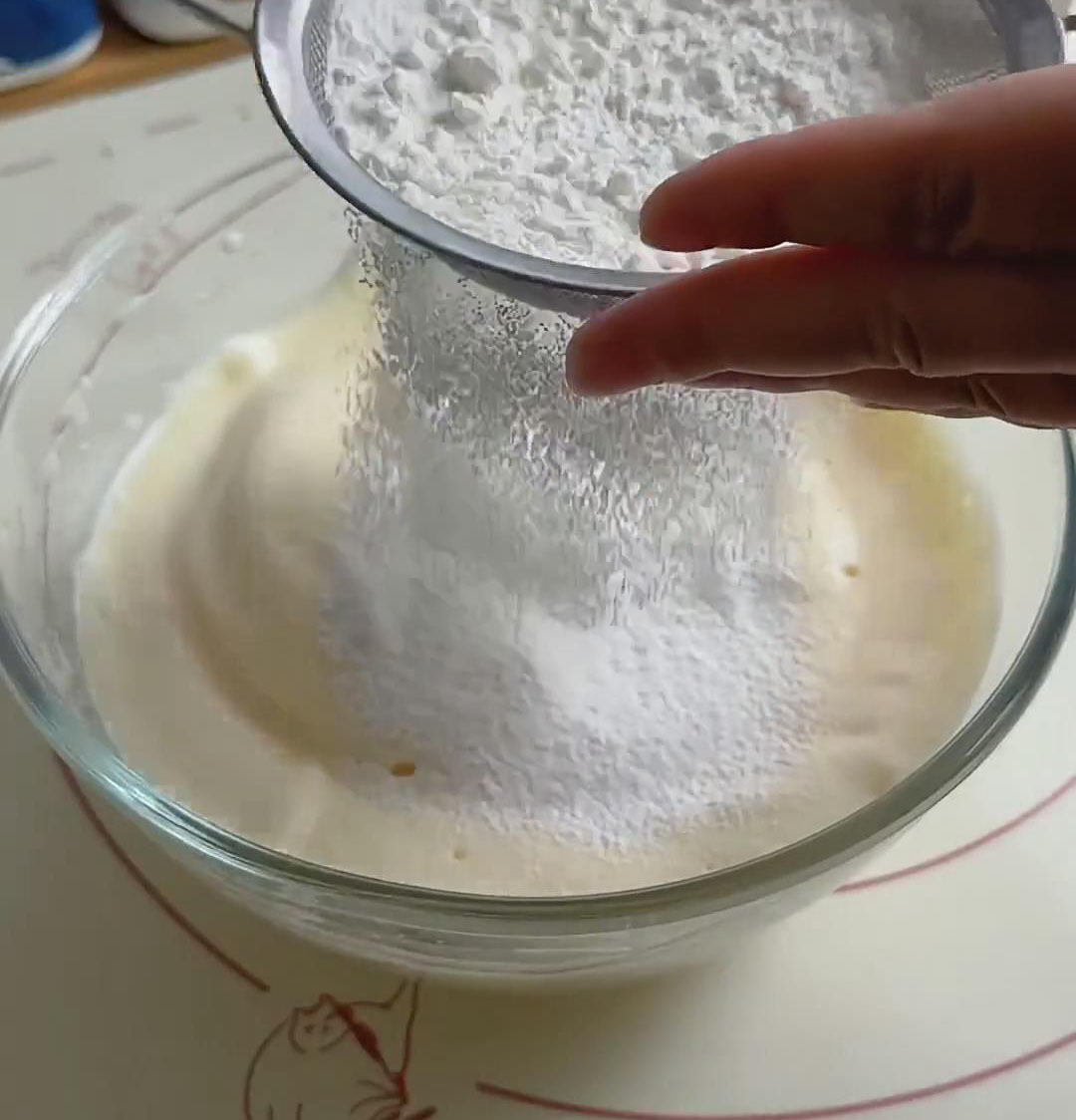 Sift the 100g of low gluten flour into the whipped egg mixture