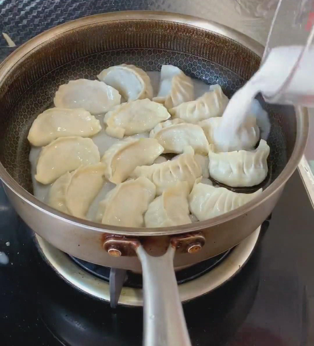 Slowly pour the prepared cornstarch water around the edges of the pan