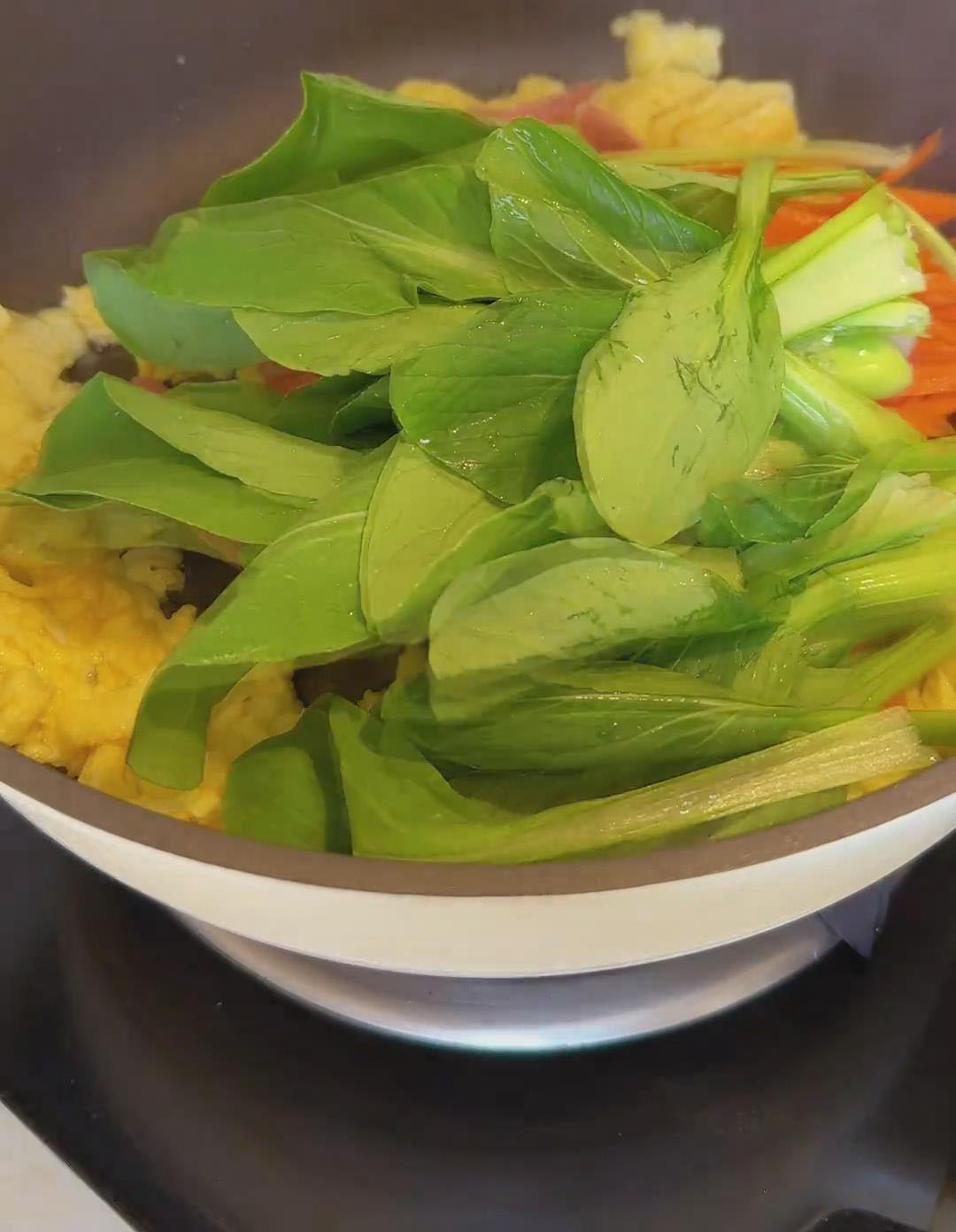 Add shredded carrots, then leafy greens, shredded ham