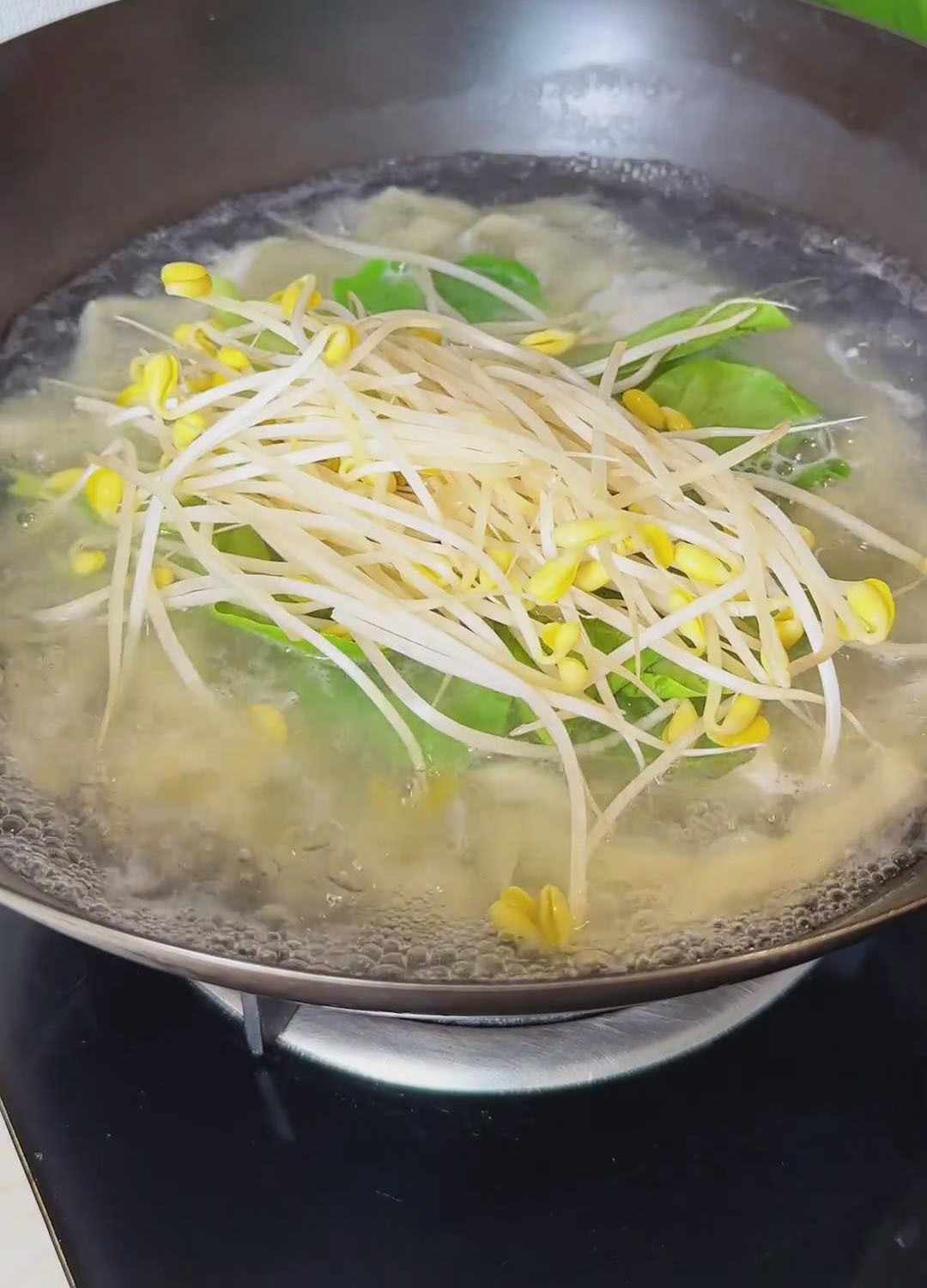 Add the bean sprouts and leafy greens