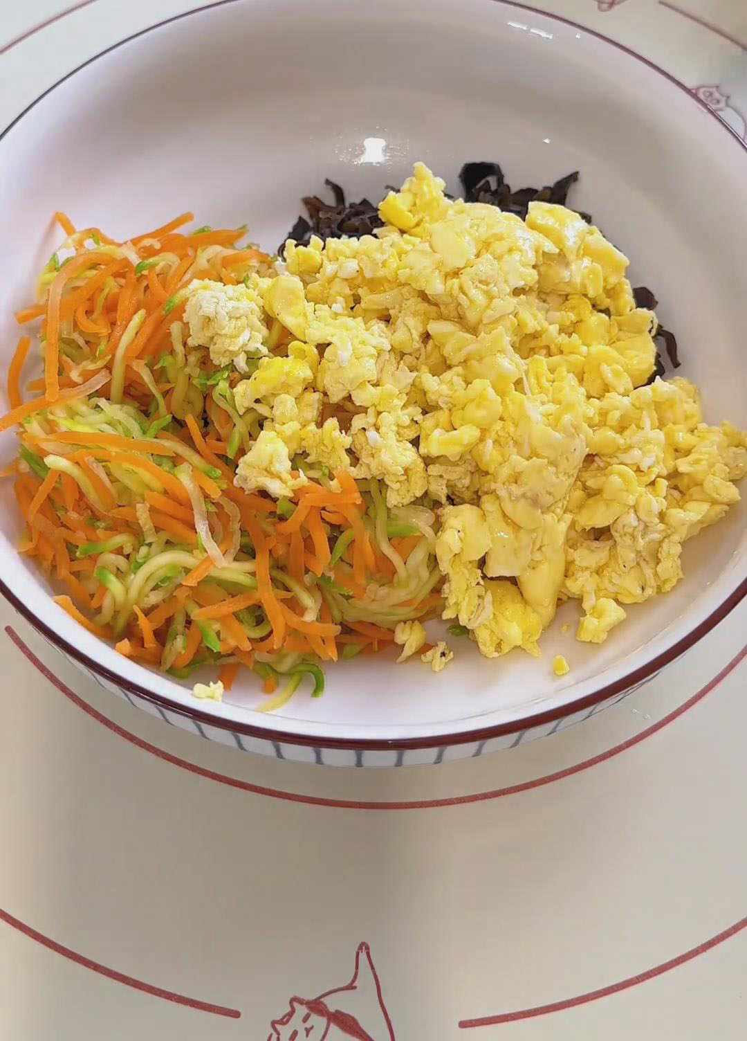 Combine the squeezed carrots and zucchini, sliced black fungus, and scrambled eggs in a large bowl Combine the squeezed carrots and zucchini, sliced black fungus, and scrambled eggs in a large bowl