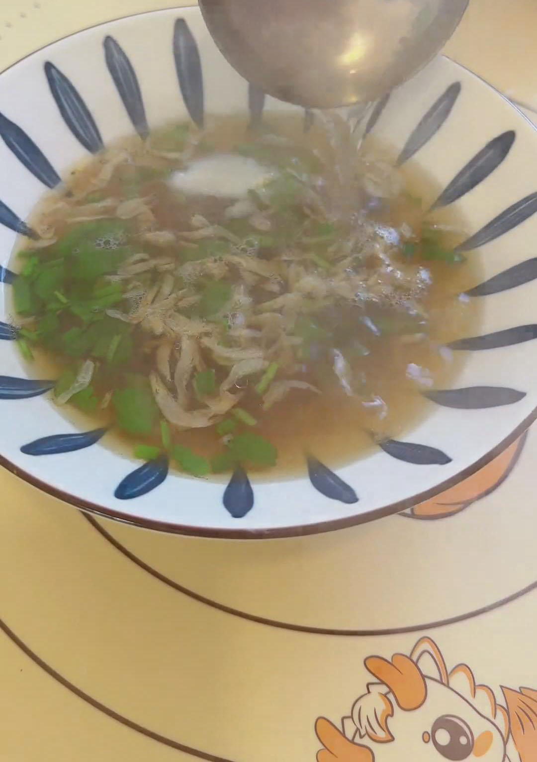 Ladle in 2–3 spoonfuls of the boiling wonton water Ladle in 2–3 spoonfuls of the boiling wonton water