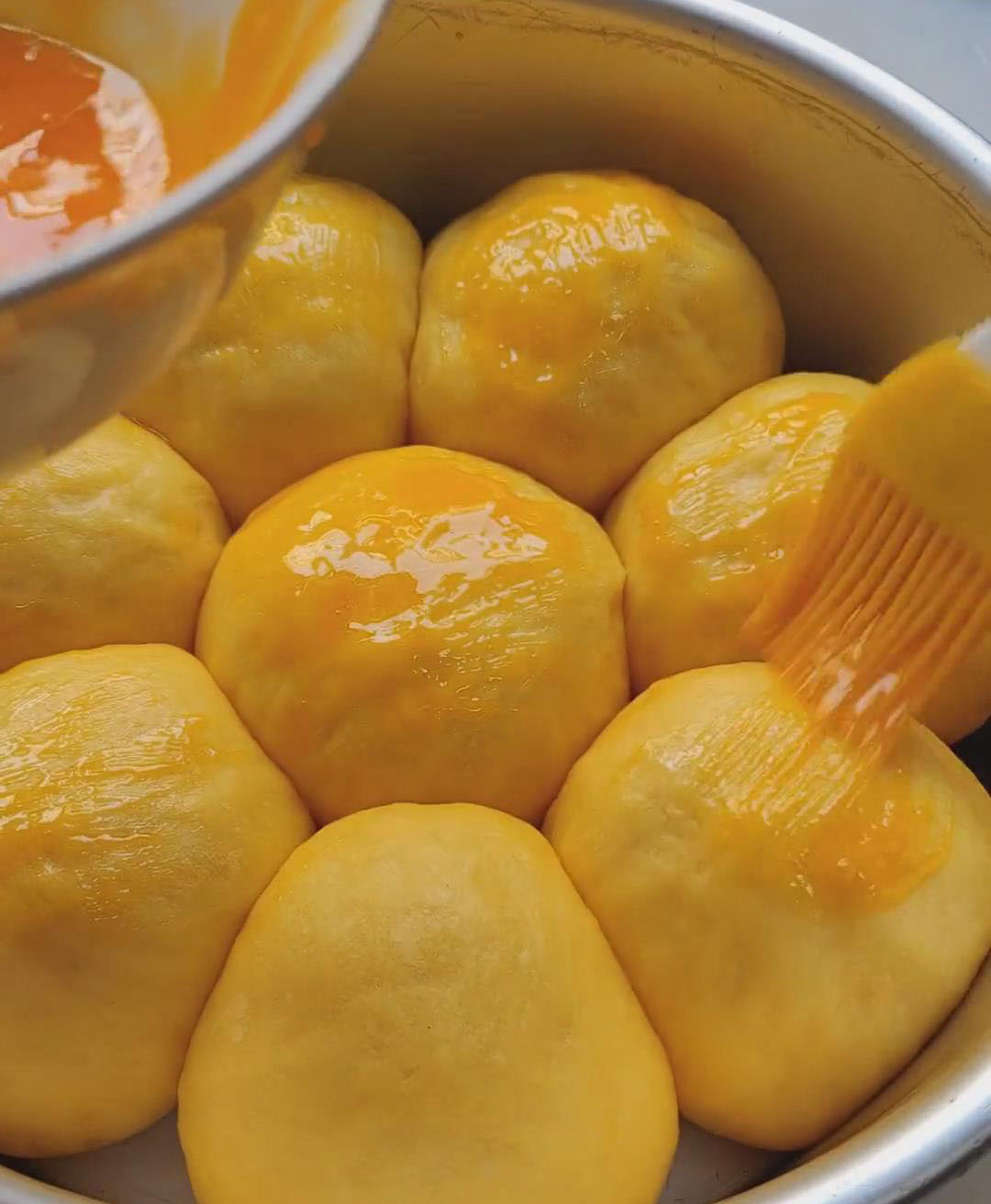 Brush a thin layer of egg yolk over the surface of each dough bal
