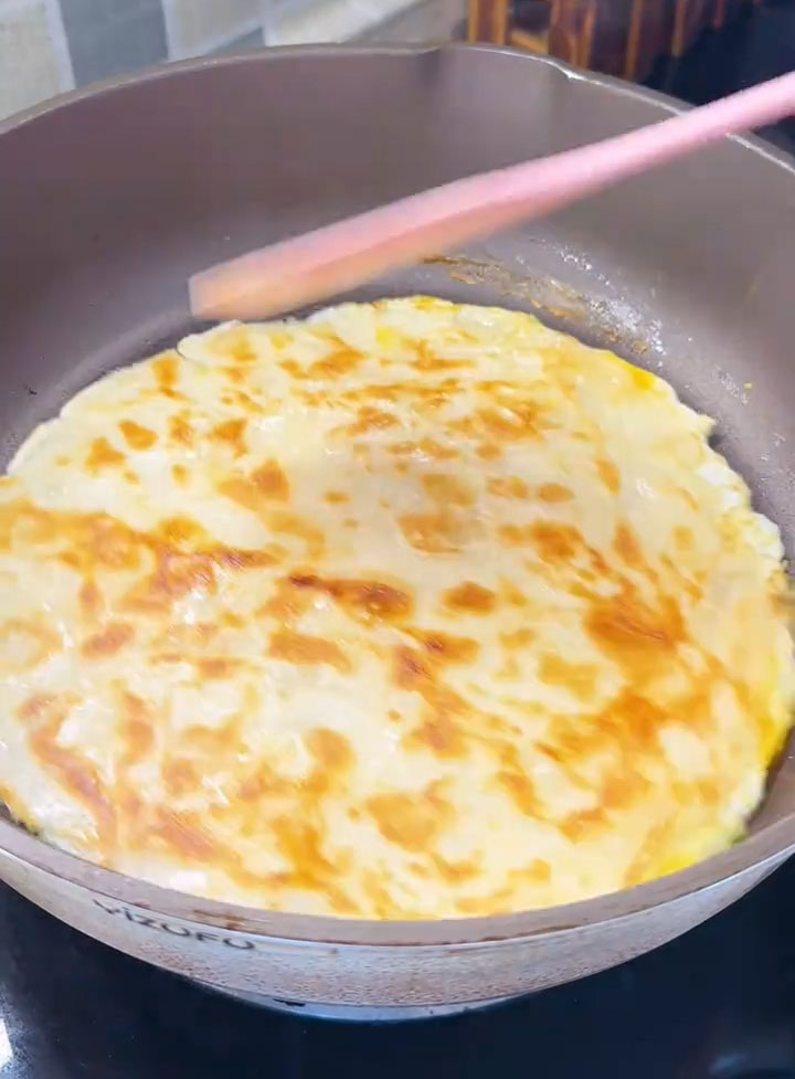 Once the egg is mostly set, carefully flip the pancake