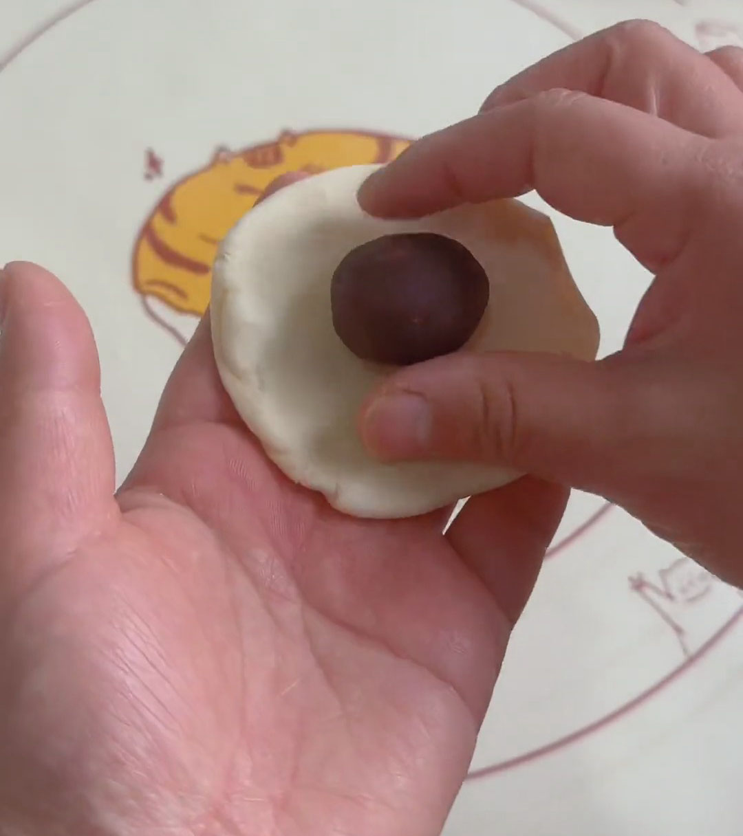 Place about 40 g of red bean paste in the center of each wrapper