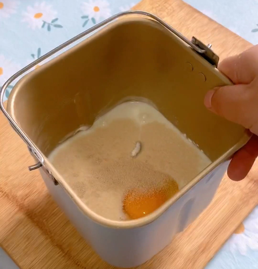 Place the bread flour, sugar, whole egg, lukewarm milk, and yeast into the bread machine pan