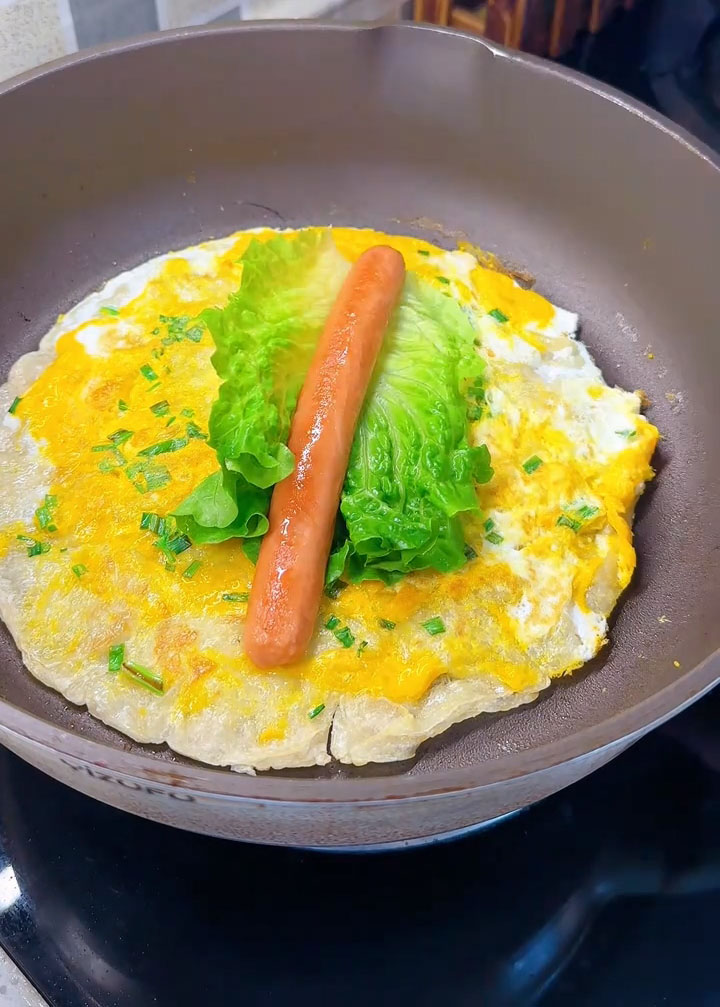 Place the lettuce and sausage slices on top of the cooked pancake