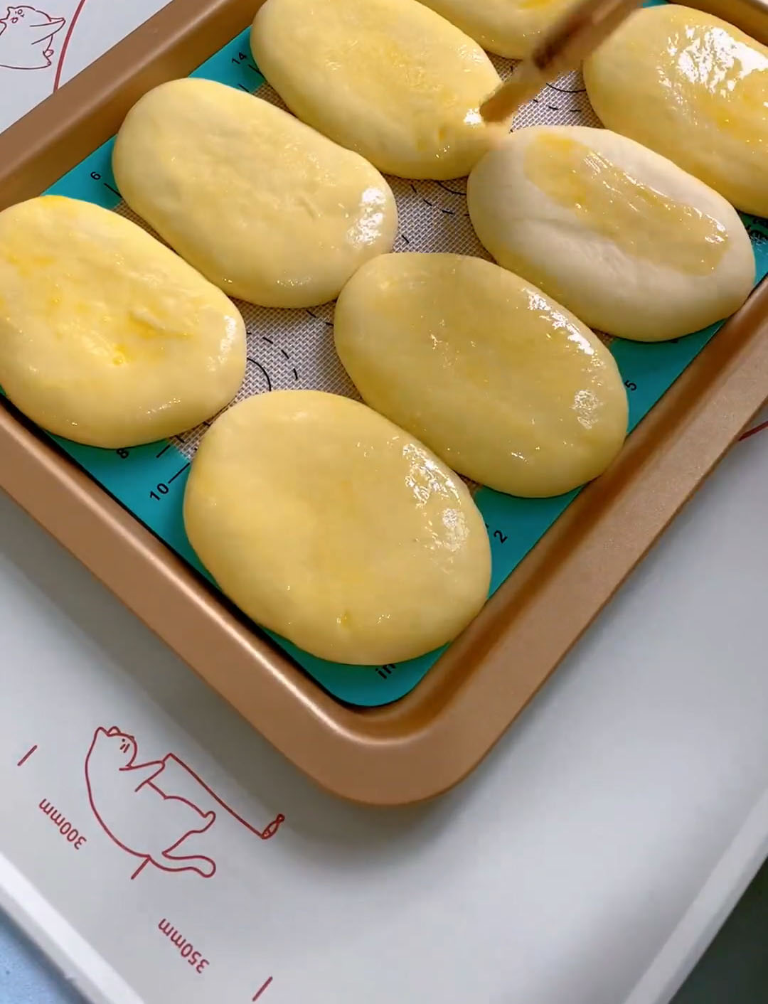 brush the tops of each proofed bun with the beaten egg wash