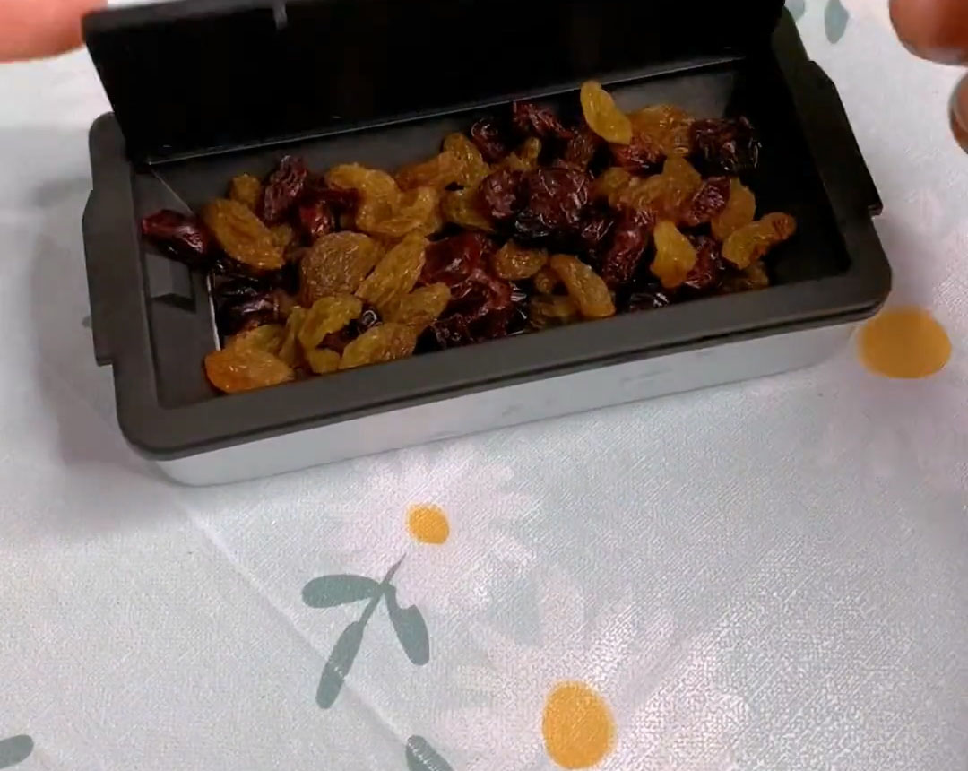 Place the prepared raisins and dried cranberries into the bread machine’s fruit dispenser