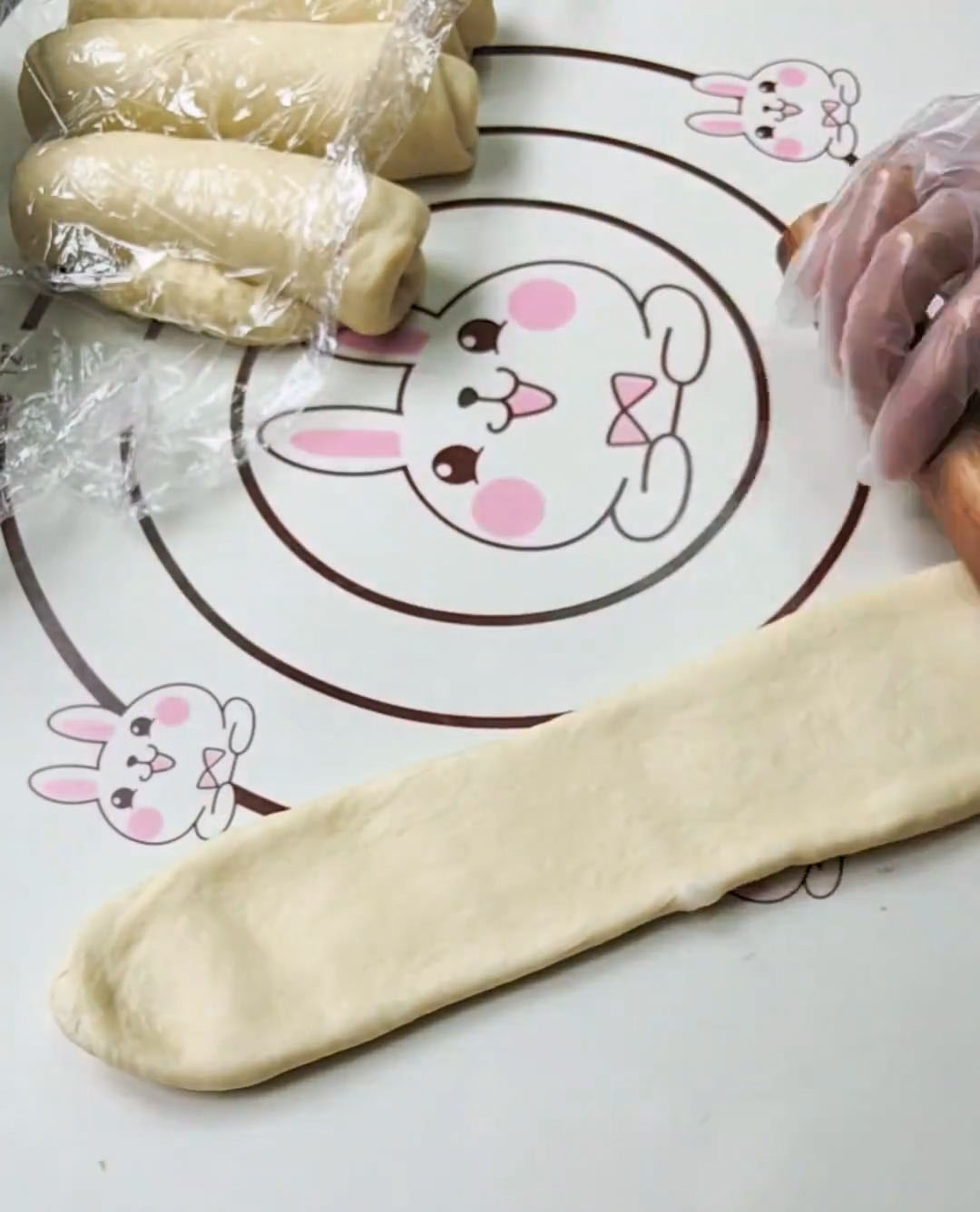 Roll each rested piece out again into a long oval and roll up tightly