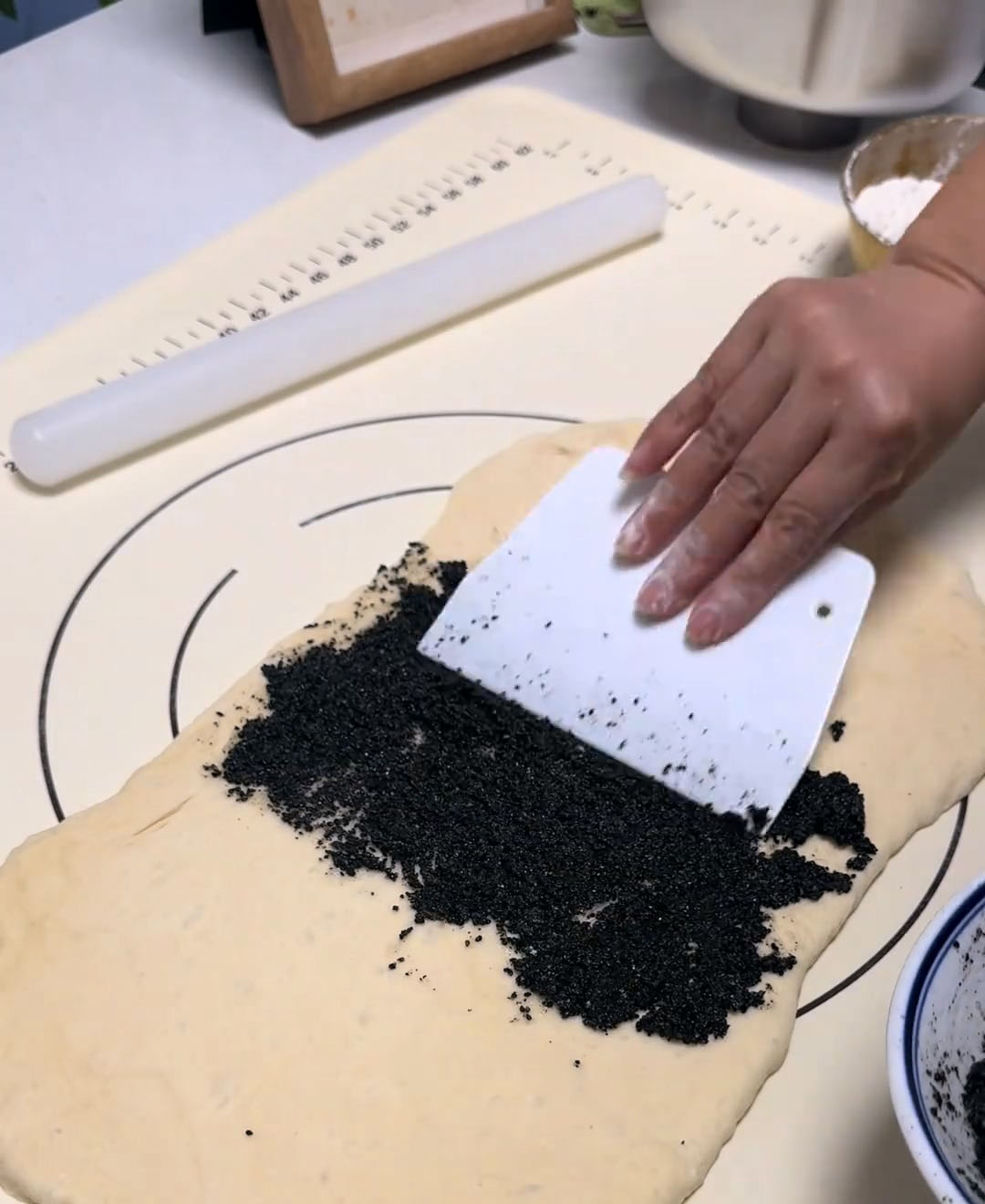 Spread an even layer of black sesame filling over the center of the dough