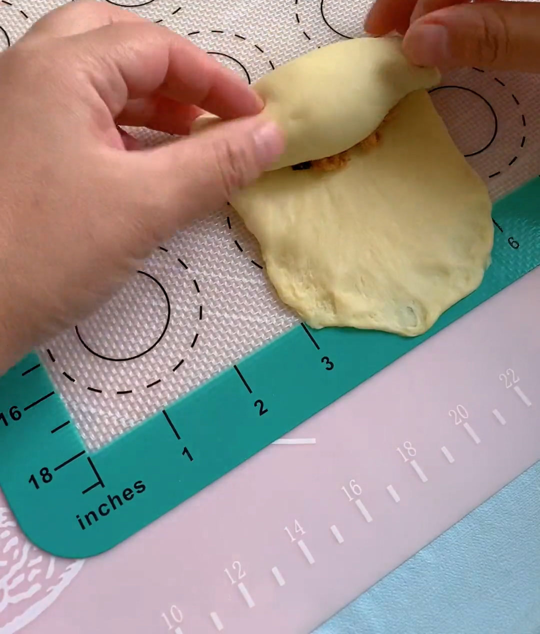 Starting from the unflattened end, roll the dough tightly toward the flattened end