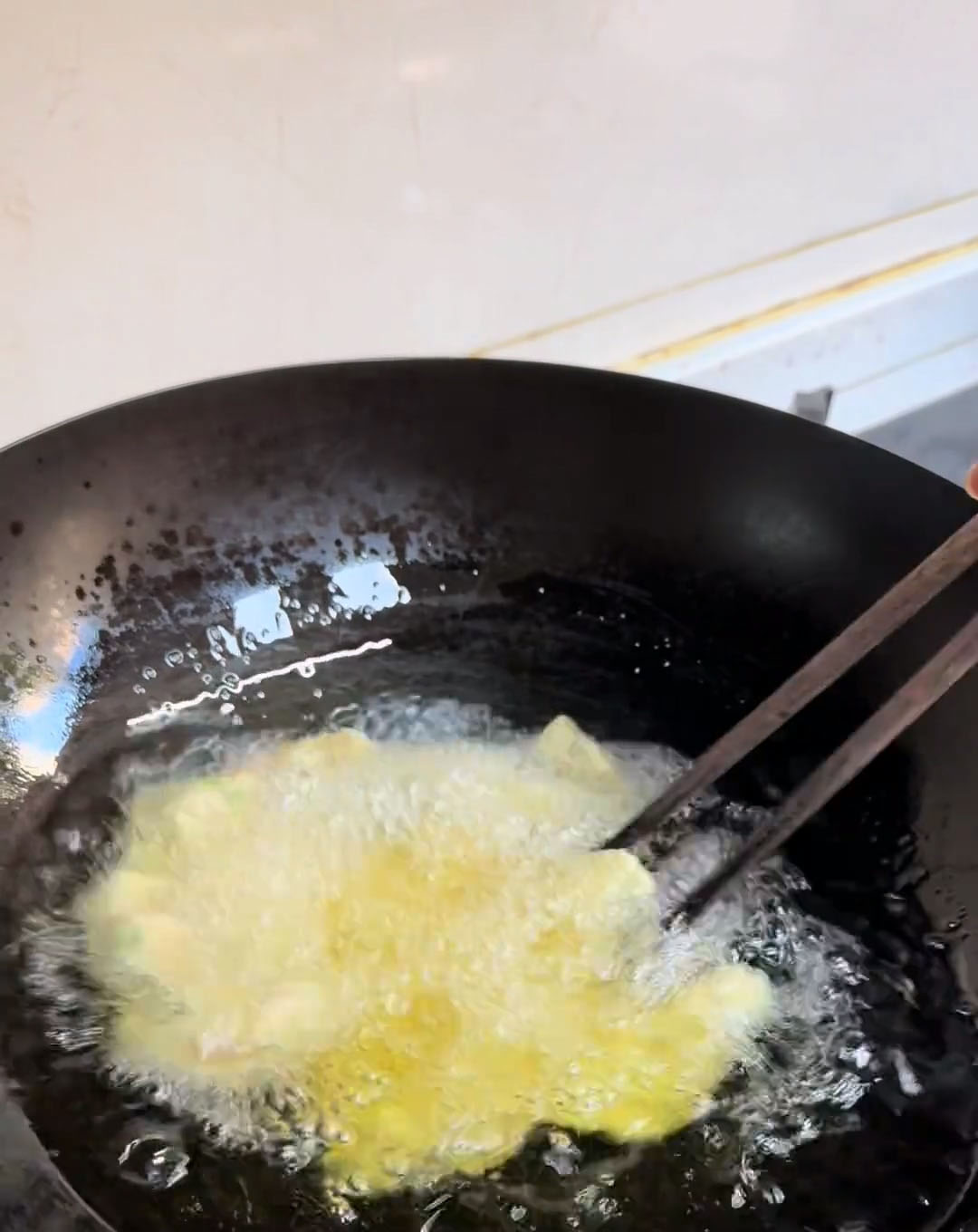 carefully add the coated pork pieces one by one into the hot oil