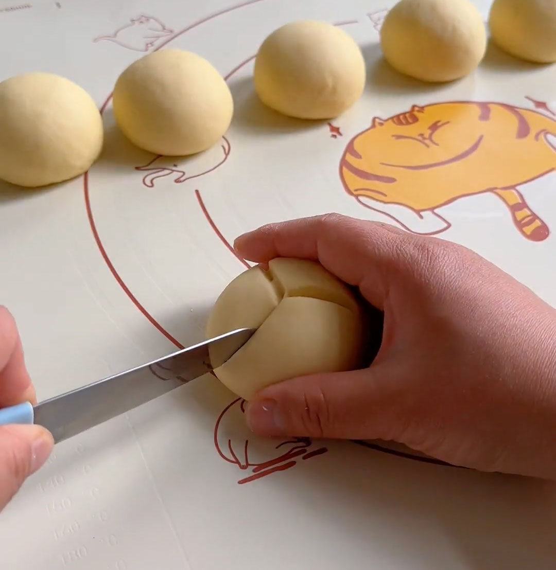 cut three shallow slashes on the surface of each bun cut three shallow slashes on the surface of each bun